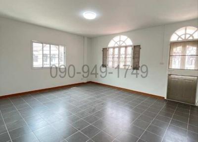 Spacious and well-lit empty living room with tiled flooring