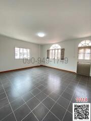 Spacious and well-lit empty living room with tiled flooring