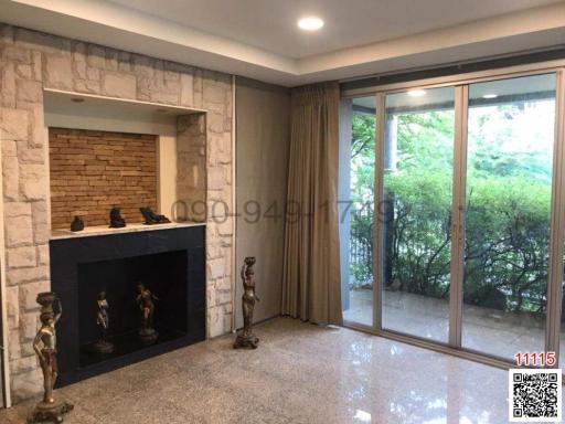 Spacious living room with a stone fireplace and large glass doors leading to the outside
