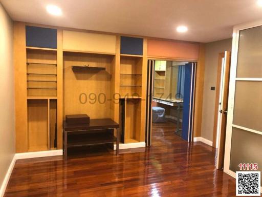Spacious living room with built-in shelving and hardwood floors