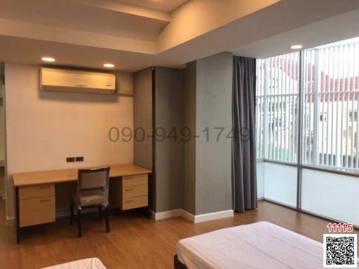 Spacious bedroom with ample natural light, modern furnishings, and an air conditioning unit