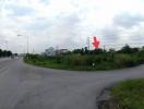 Panoramic view of a potential development site near a main road with green surroundings