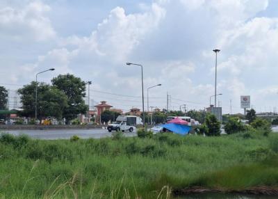 Street view near a property with visible roadside and greenery under a cloudy sky