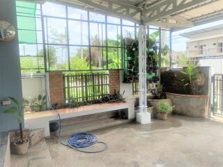 Spacious patio area with large windows and greenery