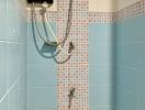 A tiled bathroom shower area with an electric shower head