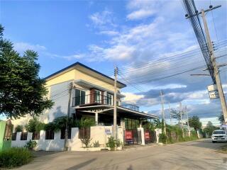 Two-story house with carport under blue sky