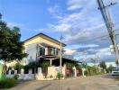 Two-story house with carport under blue sky