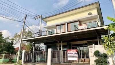 Two-story residential house with balcony and gated entrance