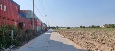 Rural road with shipping containers and agricultural land