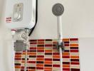 Water heater and shower head in a bathroom with red tile wall