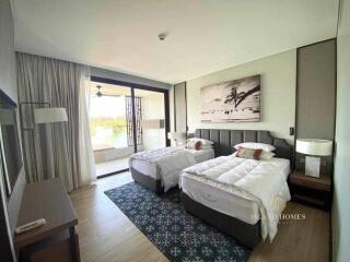 Spacious bedroom with two beds and balcony access