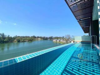 Luxurious infinity pool overlooking a serene lake with clear blue skies