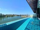 Luxurious infinity pool overlooking a serene lake with clear blue skies