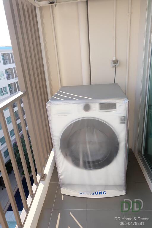 Compact balcony with a washing machine and view of apartment buildings