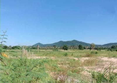 Expansive vacant land with a clear blue sky and distant mountains