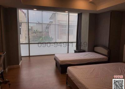 Spacious Bedroom with Large Window and Two Beds