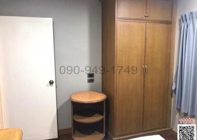 Compact bedroom with wooden wardrobe and round table