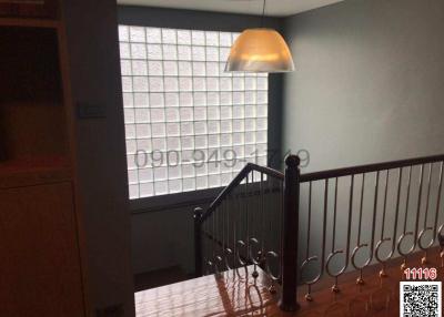 Staircase landing with glass block window and wrought iron railings