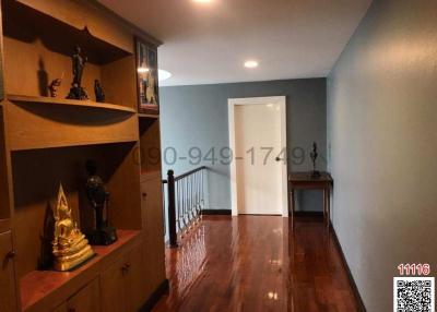 Spacious hallway with hardwood flooring and built-in shelving unit