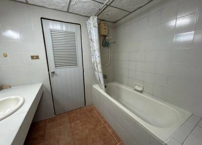 Spacious bathroom with bathtub and white tiles