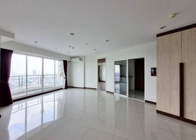 Spacious and well-lit living room with glossy tiled flooring and city view