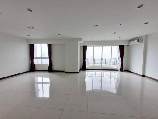 Spacious and bright empty living room with large windows and glossy tiled flooring