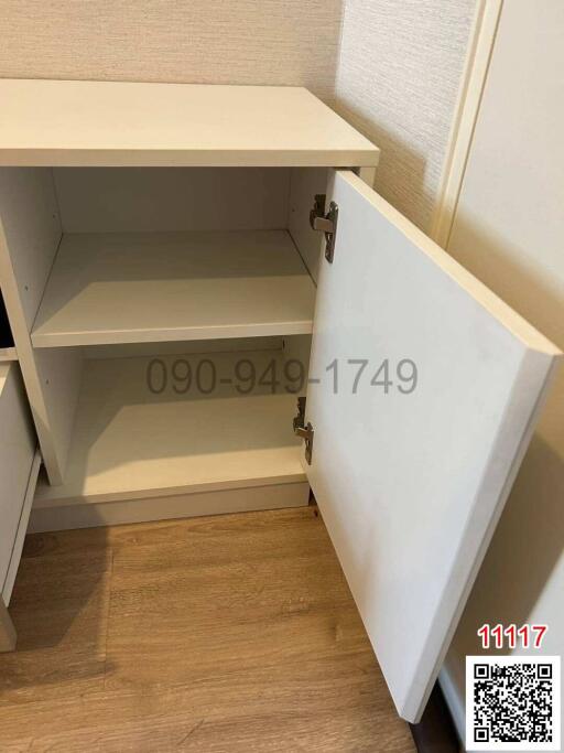 Open wooden cupboard in a room with laminate flooring