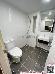 Modern bathroom with white and gray tile scheme, toilet, sink, and shower