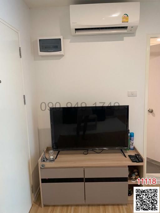 Modern living room with wall-mounted television and air conditioning unit