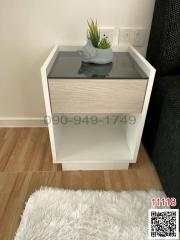 A modern bedroom with a stylish bedside table and decorative plant