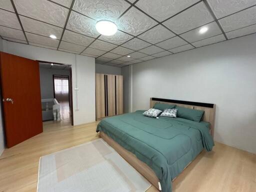 Spacious bedroom with elegant ceiling design and hardwood flooring