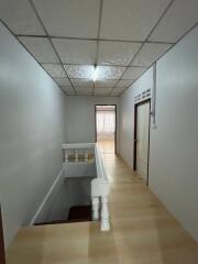Narrow hallway interior leading to rooms with wooden floors and decorative ceiling