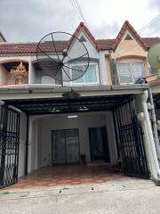 Front view of a two-story residential building with a satellite dish