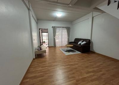 Spacious and well-lit living room area with hardwood floors and sliding door access to balcony