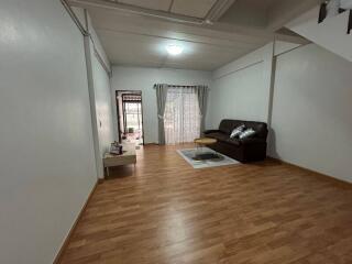 Spacious and well-lit living room area with hardwood floors and sliding door access to balcony