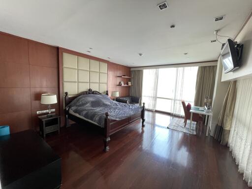 Spacious bedroom with hardwood floors and natural light