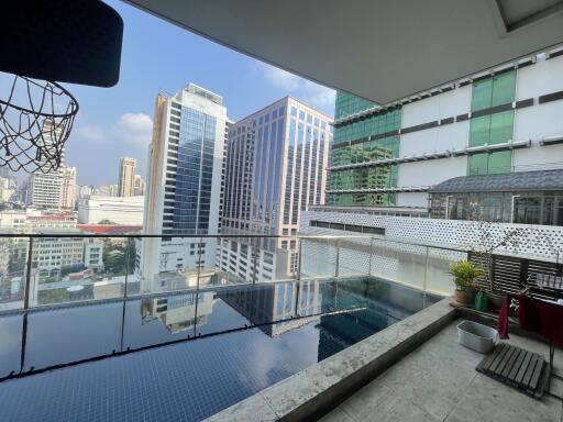 Balcony with a swimming pool overlooking the city skyline