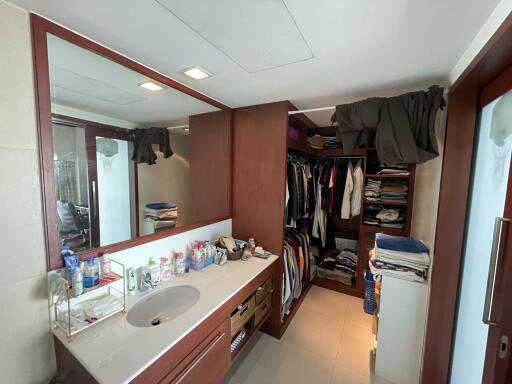 Spacious bathroom with a large mirror and adjoining walk-in closet