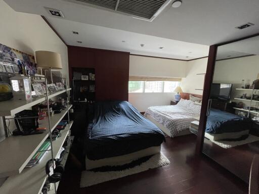 Spacious bedroom with two beds and ample natural light