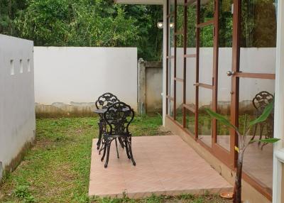 Cozy patio area with a bench and greenery