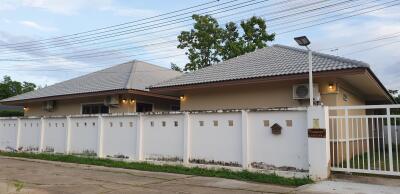 Single-story residential home with gray roof and white fence