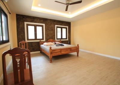 Spacious bedroom with large windows and wooden furnishings