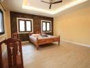 Spacious bedroom with large windows and wooden furnishings