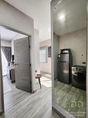 Modern Apartment Interior with Open Door Leading to Bedroom, Washer, and Refrigerator