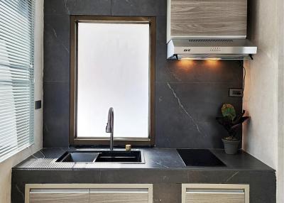 Modern kitchen with black marble walls and wooden cabinets