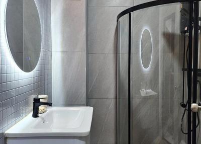 Modern bathroom with glass shower and gray tiles
