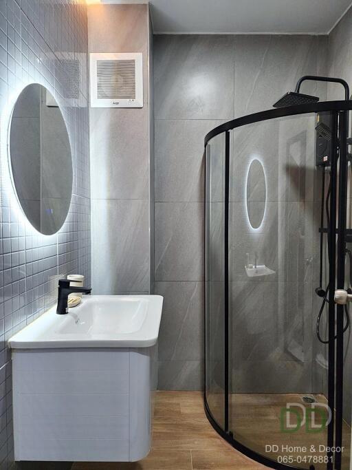 Modern bathroom with glass shower and gray tiles