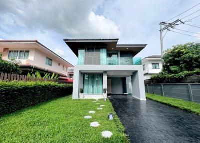 Modern two-story house with spacious lawn and clear skies