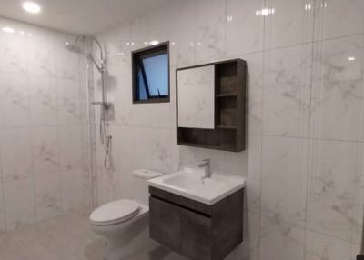 Modern bathroom with wall-mounted toilet, sink, and mirror