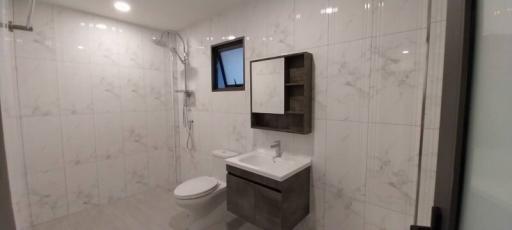 Modern bathroom with wall-mounted toilet, sink, and mirror